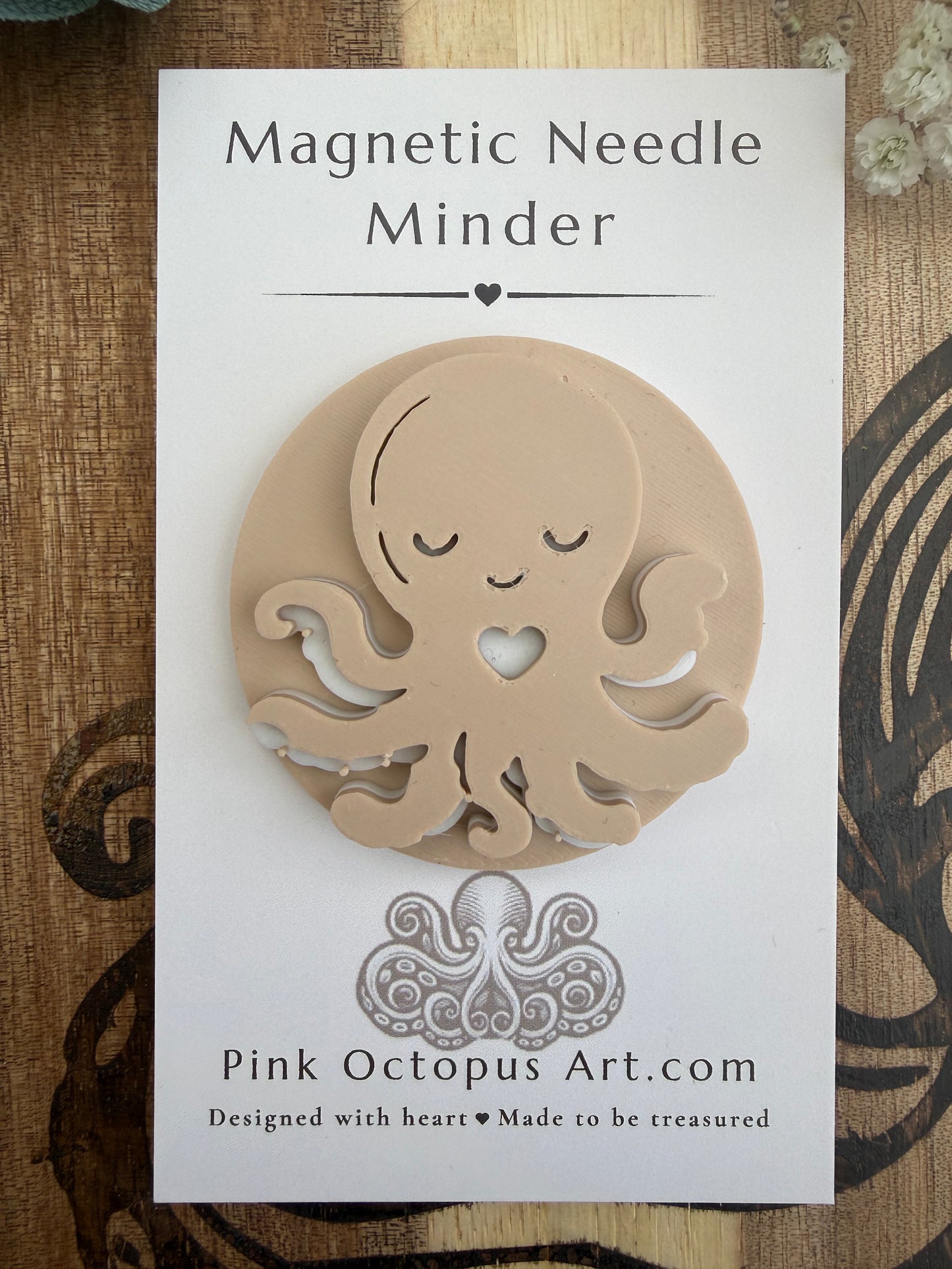 A beige octopus-shaped magnetic needle minder displayed on its white backing card, which reads 'Magnetic Needle Minder' and shows the brand 'Pink Octopus Art.com'.