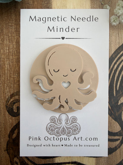 A beige octopus-shaped magnetic needle minder displayed on its white backing card, which reads 'Magnetic Needle Minder' and shows the brand 'Pink Octopus Art.com'.